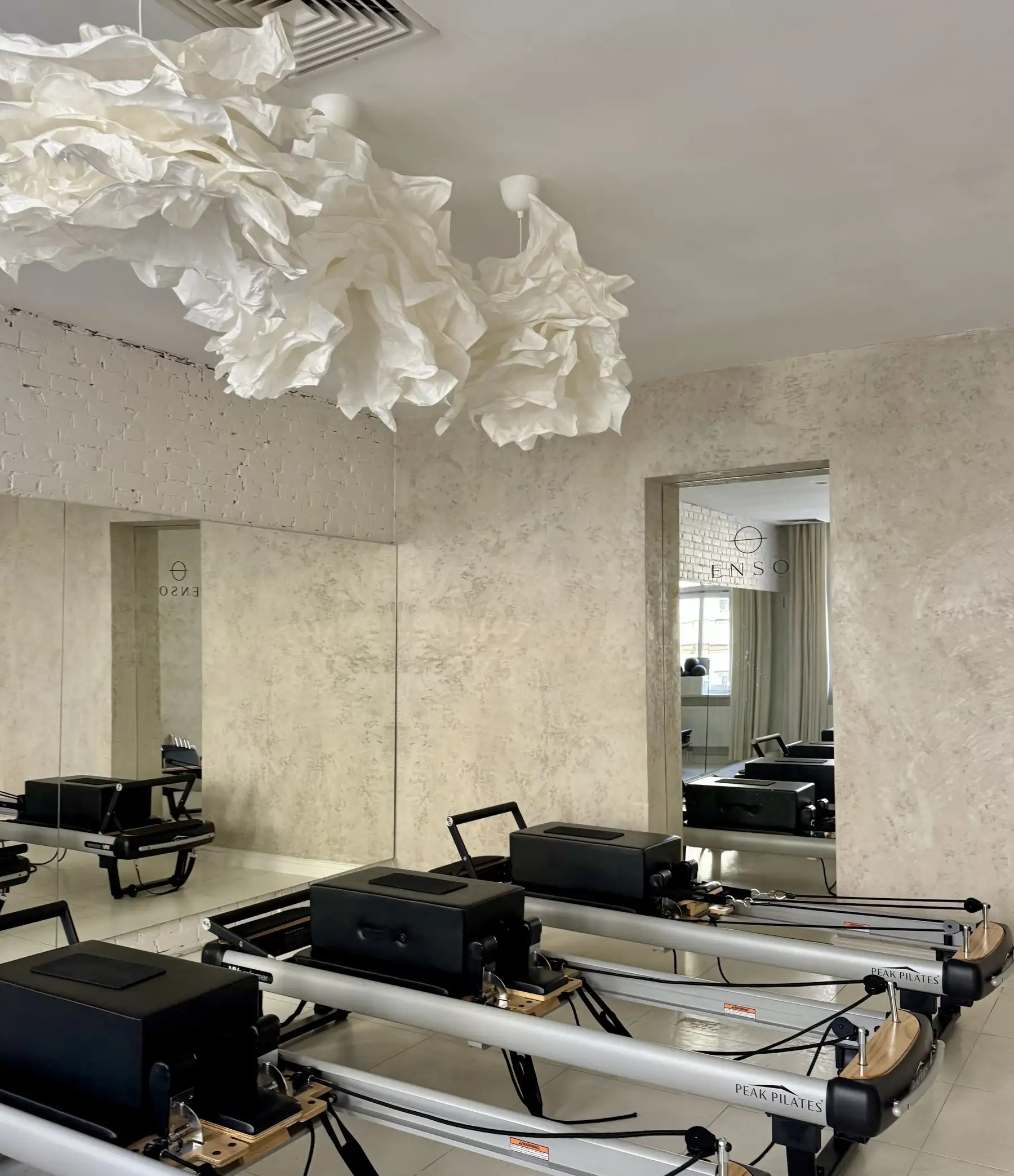Sala reformerów pod papierowymi lampami w butikowym studiu pilates w centrum Katowic