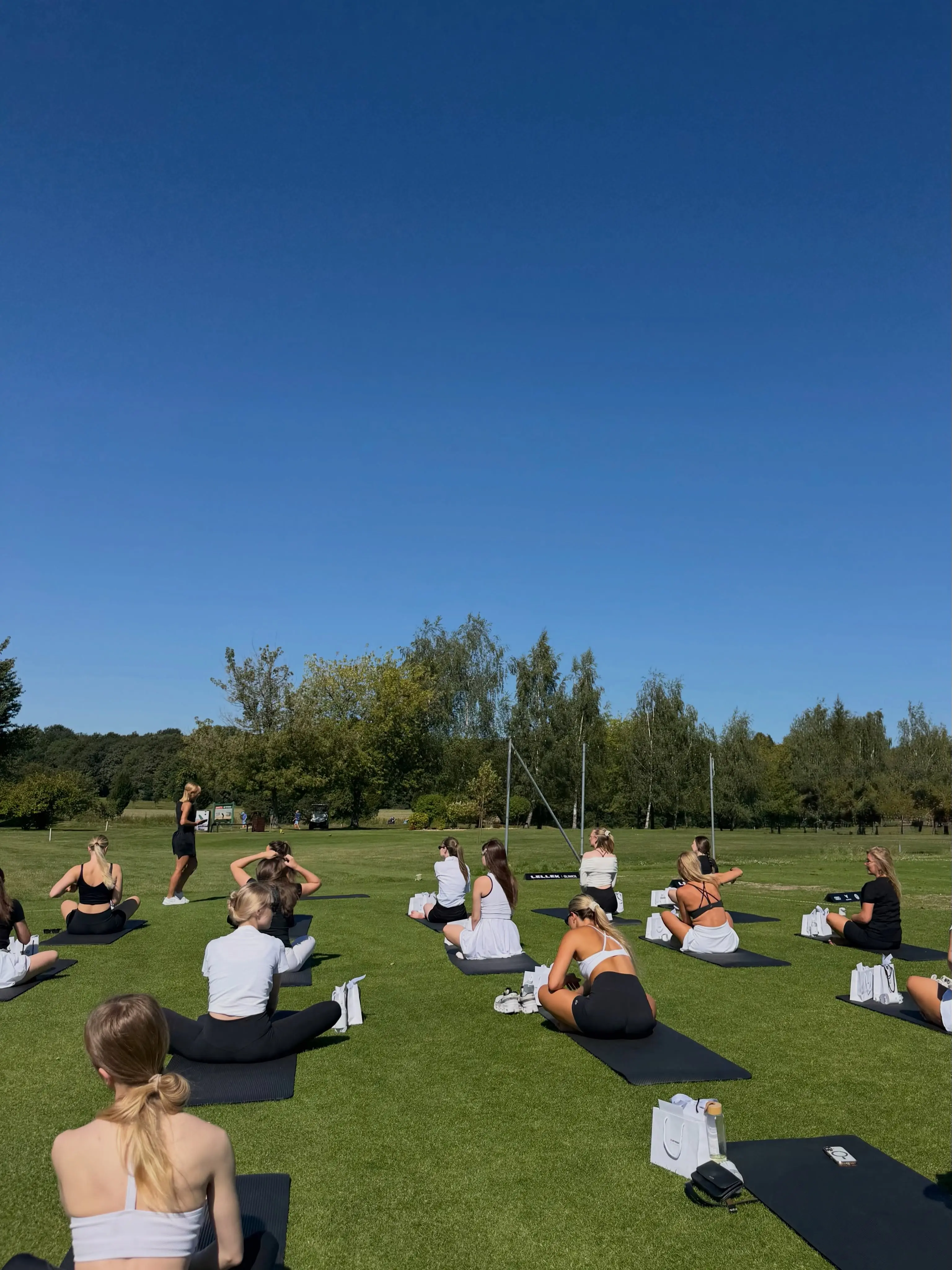 Społeczność studia pilates ENSO podczas wspólnych zajęć na trawie